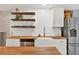 Kitchen boasts farmhouse sink, floating shelves, stainless steel dishwasher, and butcher block countertops at 6844 34Th N Ave, St Petersburg, FL 33710