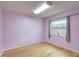 Bedroom featuring wood floor, window, and light-purple walls at 6865 Circle Creek Dr, Pinellas Park, FL 33781
