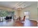 Dining room with luxury vinyl plank floors, glass top table with seating, and view of screened-in patio at 6865 Circle Creek Dr, Pinellas Park, FL 33781
