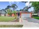 Charming single-story home featuring a lush lawn, vibrant landscaping, and an attached two-car garage at 6865 Circle Creek Dr, Pinellas Park, FL 33781