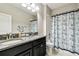 Well-lit bathroom with double vanity, granite countertop, and nautical themed shower curtain at 9816 Ivory Dr, Sun City Center, FL 33573