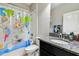Bathroom features a single sink vanity with gray countertop and a world map shower curtain at 9816 Ivory Dr, Sun City Center, FL 33573