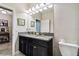 Bathroom with double sinks, decorative mirror, and gray granite countertops at 9816 Ivory Dr, Sun City Center, FL 33573