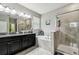Elegant bathroom with double vanity, granite countertops, soaking tub, and glass-enclosed shower at 9816 Ivory Dr, Sun City Center, FL 33573
