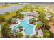 Resort-style community pool featuring lush landscaping, seating, and a clubhouse for residents' enjoyment at 9816 Ivory Dr, Sun City Center, FL 33573