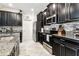 Well-appointed kitchen with dark cabinets, granite countertops, and stainless steel appliances at 9816 Ivory Dr, Sun City Center, FL 33573