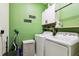 Laundry room with green walls, white cabinets, washer and dryer at 9816 Ivory Dr, Sun City Center, FL 33573