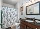 Bathroom features a dark wood vanity, a granite countertop, and a shower with a blue and white patterned shower curtain at 10436 Villa View Cir, Tampa, FL 33647