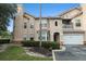 Home exterior showcasing attached garage, bay window, and quaint balcony, surrounded by neatly trimmed bushes and green space at 10436 Villa View Cir, Tampa, FL 33647