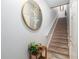 Staircase featuring carpeted steps, white railing, decorative mirror, and a stylish side table with a plant at 10436 Villa View Cir, Tampa, FL 33647