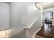 Interior staircase with carpeted steps, white railing, and hardwood flooring, with a glimpse of the dining area in the background at 10436 Villa View Cir, Tampa, FL 33647