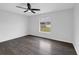Cozy bedroom featuring a ceiling fan, gray wood flooring, and window with backyard view at 11130 Summer Star Dr, Riverview, FL 33579