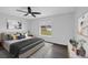 Staged bedroom featuring bed, ceiling fan, gray wood flooring, and view to the backyard at 11130 Summer Star Dr, Riverview, FL 33579