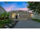 Beautiful home exterior featuring a paved driveway, well-maintained lawn, and solar panels for energy efficiency at 11130 Summer Star Dr, Riverview, FL 33579