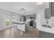 Bright kitchen with gray cabinets, stainless appliances, island, and french doors to backyard at 11130 Summer Star Dr, Riverview, FL 33579