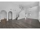 Bright living room with gray wood floors, archways, staircase, and modern chandeliers at 11130 Summer Star Dr, Riverview, FL 33579