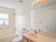 Well-lit bathroom featuring a shower-tub combo, window, and a vanity with a large mirror and cabinet at 11412 Alden Ct, Hudson, FL 34667