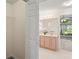 Open closet showcases vanity with double sinks, plus view to a tiled shower at 11412 Alden Ct, Hudson, FL 34667