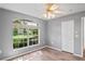 Bright bedroom features wood floors, neutral paint, ceiling fan, and window at 11412 Alden Ct, Hudson, FL 34667