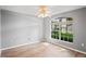 Clean bedroom features wood floors, neutral paint, ceiling fan, and large window at 11412 Alden Ct, Hudson, FL 34667
