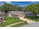 Aerial view of a home with well-maintained lawn, mature landscaping, and a long driveway to the 2 car garage at 11412 Alden Ct, Hudson, FL 34667