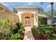 Close-up of the front entrance with lush landscaping and charming double doors at 11412 Alden Ct, Hudson, FL 34667