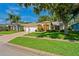 Home exterior showing a well-manicured lawn, landscaping, and a spacious driveway with a 2 car garage at 11412 Alden Ct, Hudson, FL 34667