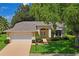 Home exterior featuring a well-manicured lawn and landscaping, a spacious driveway and a 2 car garage at 11412 Alden Ct, Hudson, FL 34667