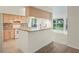Well-lit kitchen featuring granite countertops, light wood cabinetry, and modern appliances at 11412 Alden Ct, Hudson, FL 34667