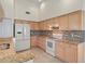 Bright kitchen featuring granite countertops, tile backsplash, white appliances, and light wood cabinetry at 11412 Alden Ct, Hudson, FL 34667