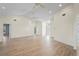 Bright living room with wood-look floors, ceiling fans, and neutral walls at 11412 Alden Ct, Hudson, FL 34667