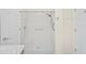 White-tiled walk-in shower with bench and safety bars at 11412 Alden Ct, Hudson, FL 34667