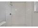 All-white walk-in shower featuring subway tile surround and chrome shower head and handle at 1207 Chevy Chase Dr, Sun City Center, FL 33573