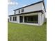 The back of the house shows a covered patio and large windows, complemented by a green lawn at 12758 Oak Hill Way, Parrish, FL 34219