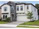 Charming two-story home features stone accents, shutters, a two-car garage, and a well-maintained lawn at 12758 Oak Hill Way, Parrish, FL 34219