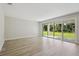 Open living room with hardwood floors and sliding glass doors to the backyard at 12758 Oak Hill Way, Parrish, FL 34219