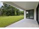 A covered patio overlooks a large, grassy backyard and lush trees, offering a serene outdoor space at 12758 Oak Hill Way, Parrish, FL 34219