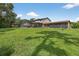 Large backyard with a screened pool enclosure and storage shed in the distance at 1357 Dinsmore Ct, New Port Richey, FL 34655