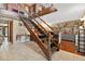 Inviting foyer with wooden staircase leading to upper level and tile flooring throughout the main area at 1357 Dinsmore Ct, New Port Richey, FL 34655