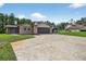 View of the exterior features an attached garage, stone driveway, and well-manicured lawn at 1357 Dinsmore Ct, New Port Richey, FL 34655