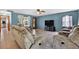 Spacious living room with comfortable reclining furniture, a ceiling fan, and lots of natural light at 1357 Dinsmore Ct, New Port Richey, FL 34655