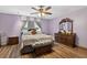 Comfortable bedroom with hardwood floors, a large bed, and a decorative bench at 1357 Dinsmore Ct, New Port Richey, FL 34655