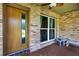 Covered front porch featuring decorative brick, ceiling fan, accent lighting, and bench seating at 1357 Dinsmore Ct, New Port Richey, FL 34655