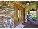 Charming front porch with double doors, ceiling fans, brickwork, and rocking chair seating at 1357 Dinsmore Ct, New Port Richey, FL 34655