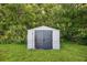 Backyard view of a shed with gray doors and a light gray exterior at 1357 Dinsmore Ct, New Port Richey, FL 34655