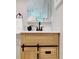 Charming bathroom vanity with wood cabinets, sliding barn door detail, and a modern faucet at 140 88Th Ne Ave, St Petersburg, FL 33702
