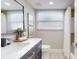 Modern bathroom featuring a dark wood vanity, white countertop, contemporary fixtures, and natural light at 140 88Th Ne Ave, St Petersburg, FL 33702