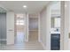 Bright bathroom featuring a blue vanity with gold hardware and an adjacent hallway with white doors at 140 88Th Ne Ave, St Petersburg, FL 33702