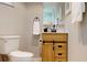 Well-lit bathroom showcasing wood vanity with sliding barn door accents, a toilet, and stylish decor at 140 88Th Ne Ave, St Petersburg, FL 33702