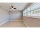 Bright bedroom with hardwood floors, ceiling fan, and bright light from large windows at 140 88Th Ne Ave, St Petersburg, FL 33702